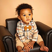 Ki'Zyier joined the competition — help win amazing prizes! armchair, barefoot, black_chair, bow_tie, child, curious, curly_hair, cute, expression, fashion, feet, hands, indoor, plaid_shirt, portrait, seated, studio_photo, toddler, warm_lighting, young_child