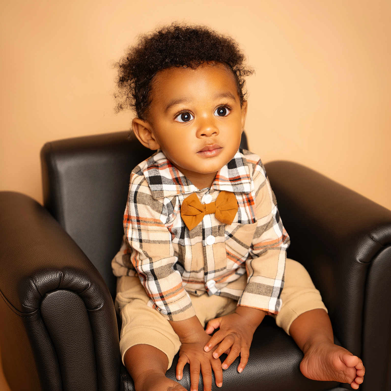 Ki'Zyier joined the competition — help win amazing prizes! armchair, barefoot, black_chair, bow_tie, child, curious, curly_hair, cute, expression, fashion, feet, hands, indoor, plaid_shirt, portrait, seated, studio_photo, toddler, warm_lighting, young_child