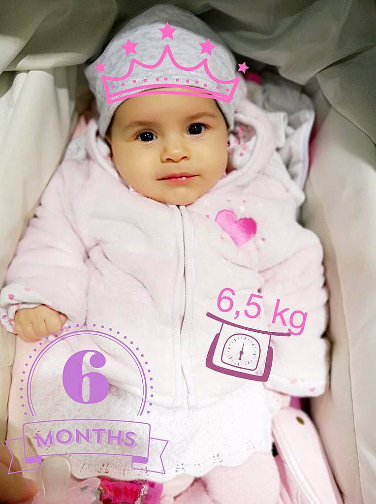 Jana participe au concours pour gagner de l'argent avec cette photo : baby, baby_toddler_clothing, child, hair_accessory, headwear, outerwear, person, pink, skin, smile, toddler