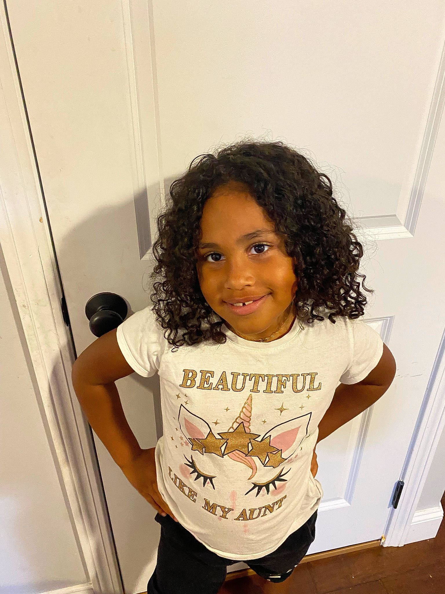 Amirah is registered to the contest to win money with this photo: child, eyelash, fashion_design, flooring, fun, hairstyle, happy, joint, joy, knee, person, ringlet, room, shoulder, sleeve, smile, standing, t_shirt, thigh, thumb