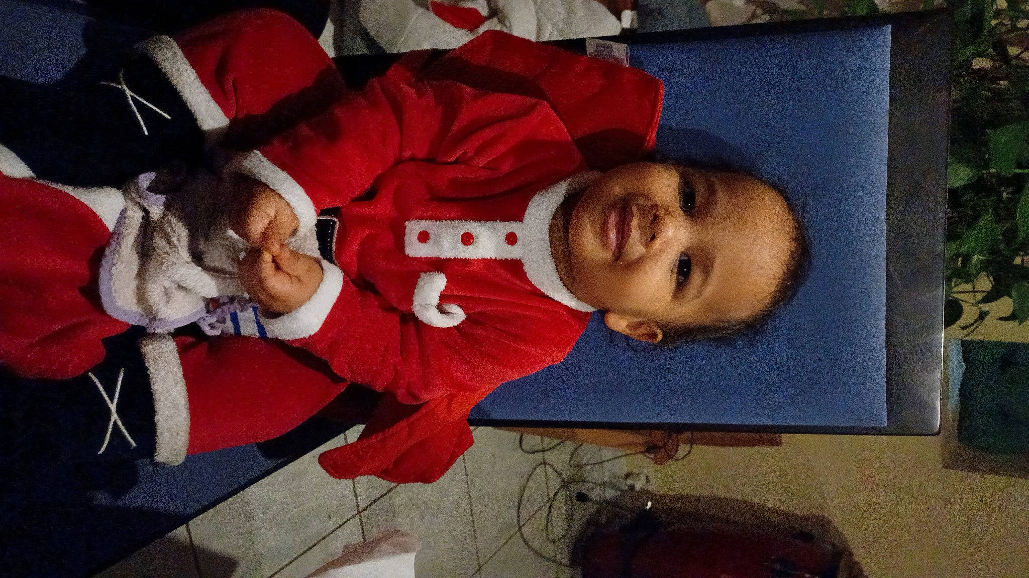 Ydris participe au concours pour gagner de l'argent avec cette photo : baby, baby_toddler_clothing, carmine, child, event, facial_expression, fictional_character, fun, happy, hat, holiday, joy, lap, laugh, mouth, person, room, santa_claus, smile, toddler