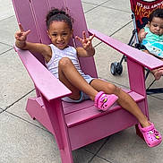 Iyasia joined the competition — help win amazing prizes! child, baby, toddler, smiling, peace_sign, sitting, stroller, lounge_chair, pink, outdoor, sidewalk, pavement, summer, curly_hair, portrait, casual_clothing, pink_shoes, infant, family, happy