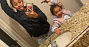 Iyasia joined the competition — help win amazing prizes! child, girl, sibling, selfie, mirror, bathroom, smiling, playful, funny_face, braid, hair, jacket, pajamas, toy, countertop, granite, sink, faucet, soap_bottle, portrait