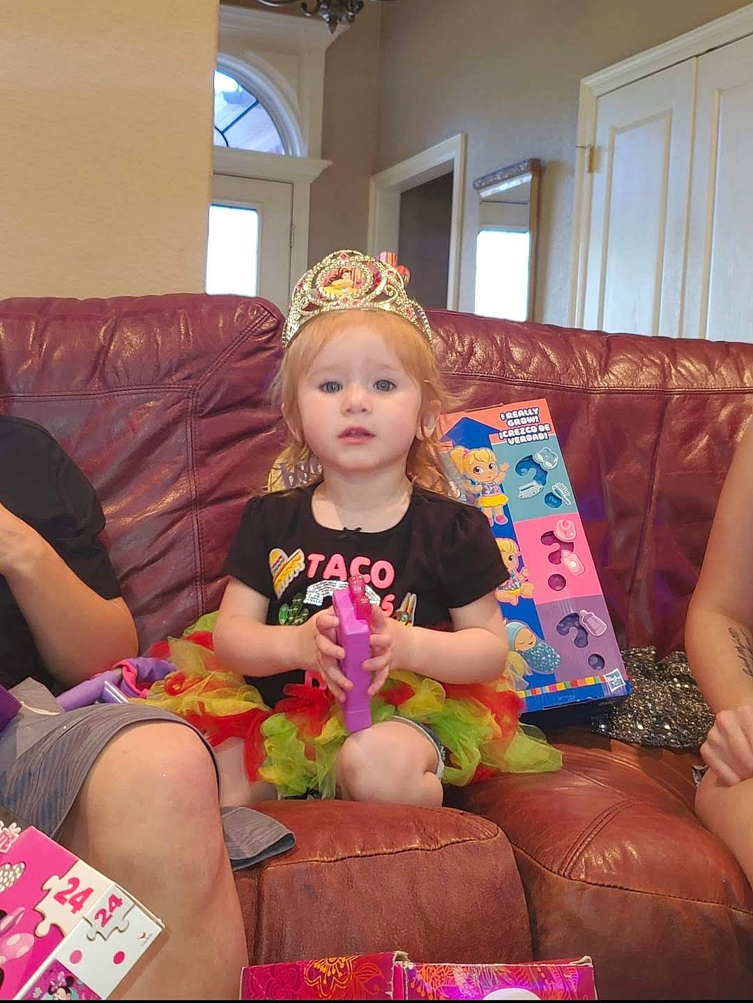 Abigail is registered to the contest to win money with this photo: child, comfort, couch, door, event, fashion_accessory, fun, happy, headpiece, human_leg, jewellery, lap, living_room, magenta, person, pink, room, sitting, thigh, toddler