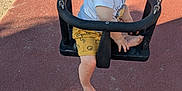 Gabriel participe au concours pour gagner de l'argent avec cette photo : toddler, child, baby_swing, playground, pacifier, shorts, white_shirt, legs, barefoot, chains, outdoor, sunlight, shadow, people, sand, rubber_flooring, smile, curly_hair, person, feet