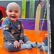 Noah joined the competition — help win amazing prizes! baby, child, smiling, sitting, reflection, socks, sweater, bear_pattern, playroom, colorful, indoor, floor_mat, happy, young_child, cute, cozy_clothing, orange_mat, reflection_surface, toys, bright