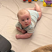 Casen joined the competition — help win amazing prizes! baby, infant, tummy_time, onesie, playmat, toy, colorful_toys, blanket, diaper, indoor, curious, lying_down, portrait, face, hands, floor, play_area, soft_toy, wooden_floor, living_room