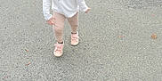 Zélya participe au concours pour gagner de l'argent avec cette photo : toddler, child, outdoor, pavement, grass, curb, sidewalk, happy, walking, shoes, braids, long_sleeve_shirt, pants, smiling, young_child, daylight, casual_clothing, nature, playful, person