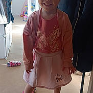 Zélya participe au concours pour gagner de l'argent avec cette photo : child, smiling, barefoot, indoors, pink_clothing, skirt, cardigan, butterfly, slippers, floor, coat, home, person, happy, standing, toy, doorway, light, playful, cute