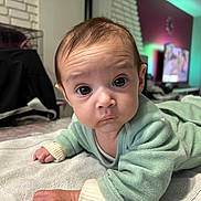 Elynn a rejoint le concours — aidez-le/la à gagner de superbes lots ! baby, infant, child, face, eyes, hand, clothing, towel, indoor, furniture, television, blanket, person, portrait, curious, expression, skin, hair, room, floor