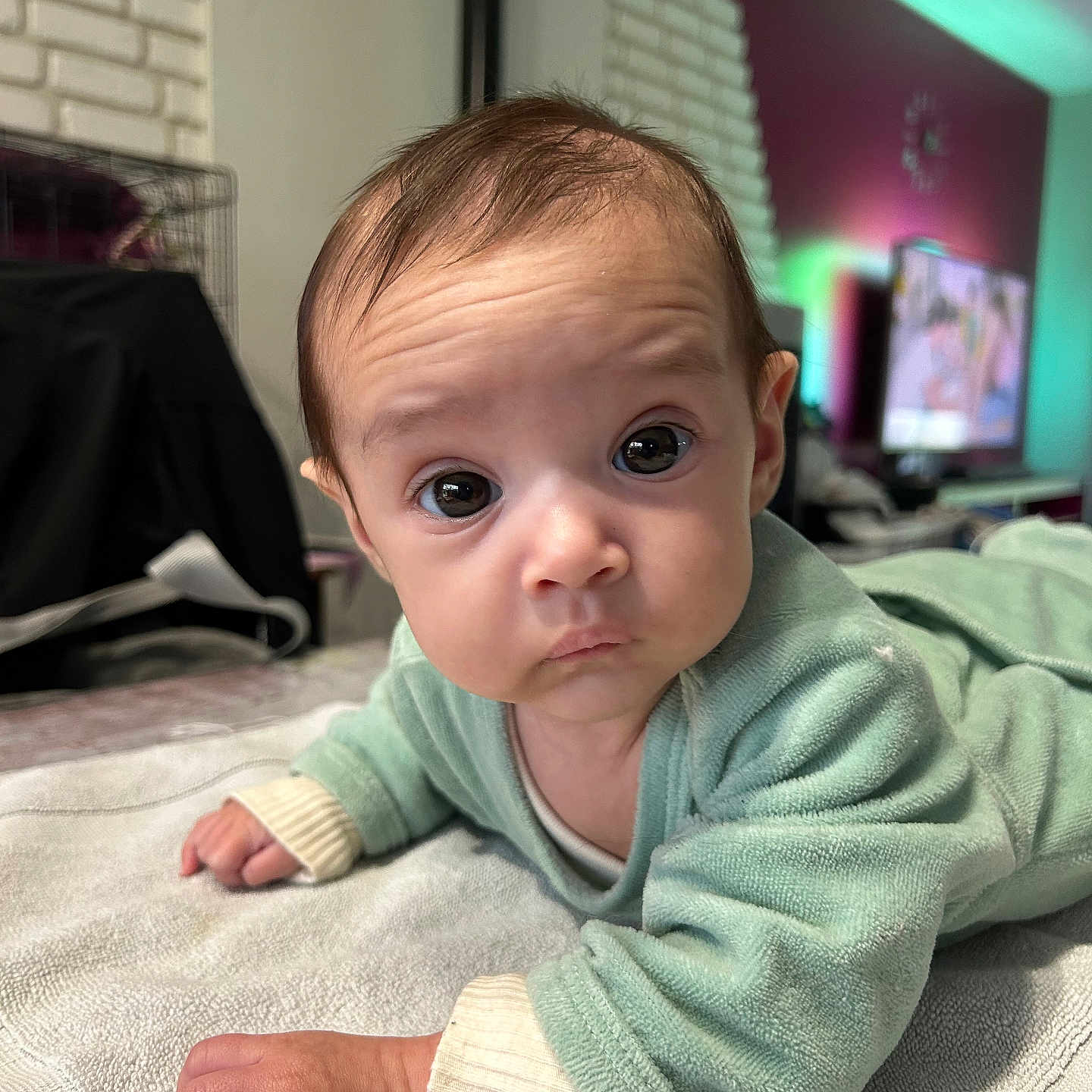 Elynn a rejoint le concours — aidez-le/la à gagner de superbes lots ! baby, infant, child, face, eyes, hand, clothing, towel, indoor, furniture, television, blanket, person, portrait, curious, expression, skin, hair, room, floor