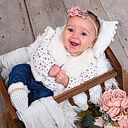 Kiara is registered to the contest to win money with this photo: baby, blanket, blue_jeans, child, cozy, cute, floral, flowers, fur, happy, headband, indoors, infant, pink, portrait, sitting, smiling, soft_texture, white, wooden_basket