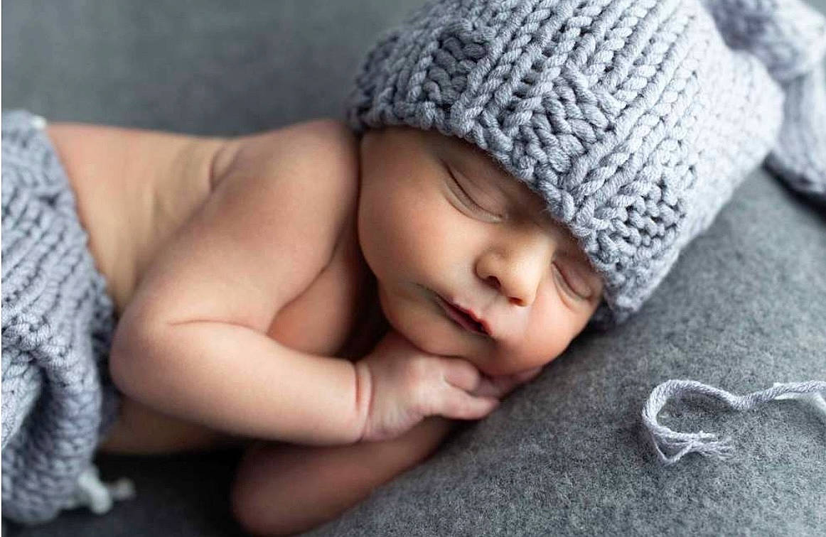 Cason is registered to the contest to win money with this photo: arm, baby, baby_sleeping, cap, comfort, finger, flooring, gesture, grey, hand, headgear, headwear, linens, lip, nail, nose, person, product, skin, thumb