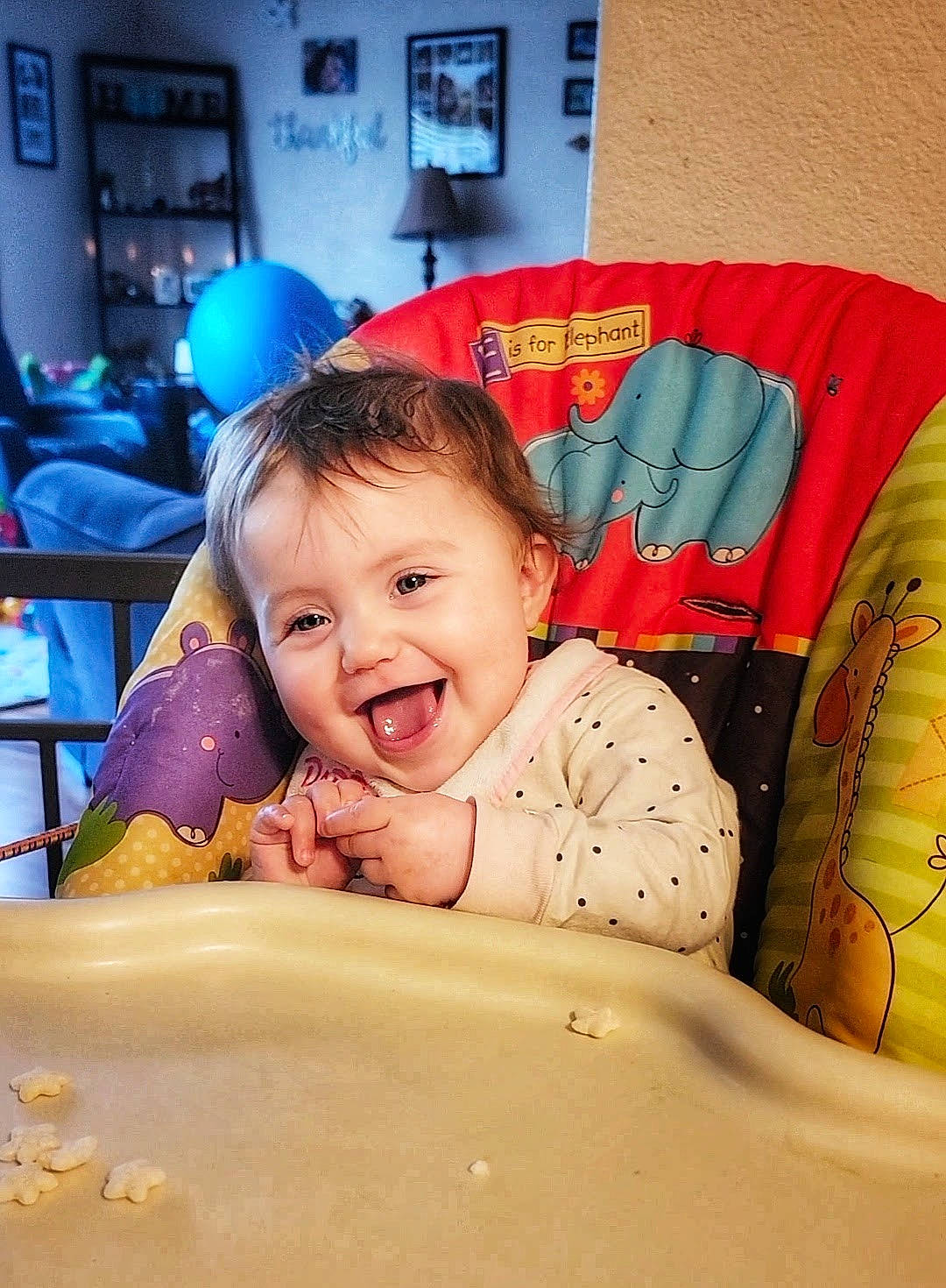 Gwendolyn is registered to the contest to win money with this photo: baby, chair, child, comfort, eating, finger, fun, hairstyle, happy, laugh, linens, mouth, person, picture_frame, pillow, play, room, sitting, smile, t_shirt