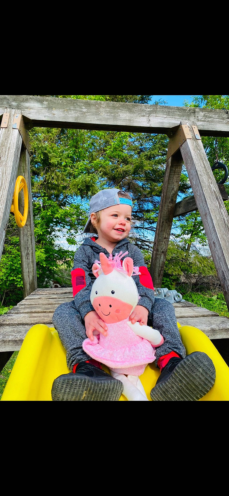 Kaliah is registered to the contest to win money with this photo: child, electric_blue, event, fun, grass, happy, headwear, jeans, joy, lap, leisure, magenta, outdoor_play_equipment, person, plant, playground, recreation, sitting, swing, toddler