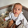 Tiago participe au concours pour gagner de l'argent avec cette photo : baby, infant, child, playpen, white_shirt, brown_pants, barefoot, curious, indoors, soft_lighting, animal_pattern, comfort, cute, looking_up, expression, seated, face, person, young, cozy