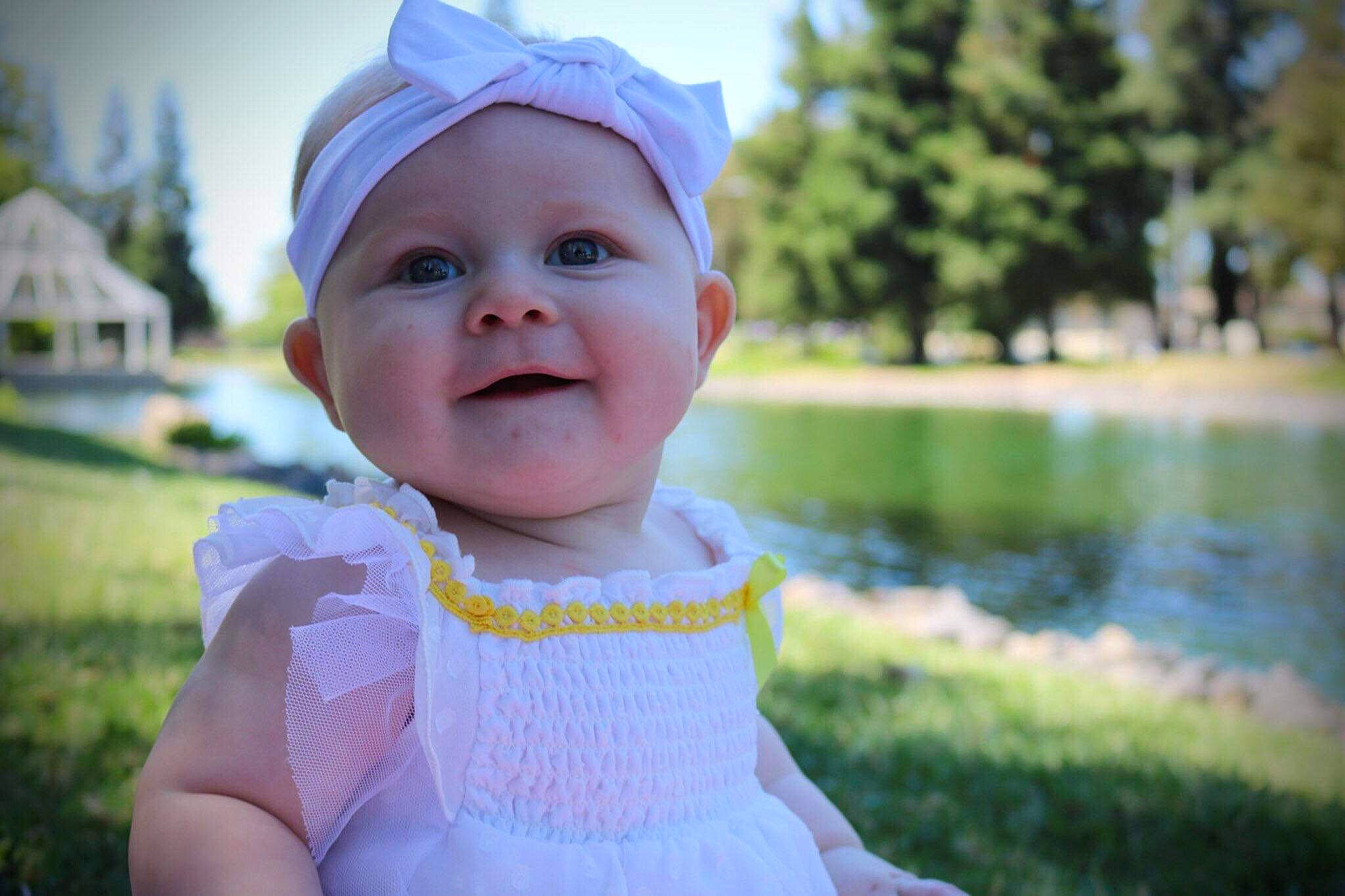 Mya joined the competition — help win amazing prizes! baby, bonnet, cheek, child, dress, eye, face, facial_expression, grass, head, headgear, lip, outerwear, person, photograph, pink, skin, smile, summer, toddler