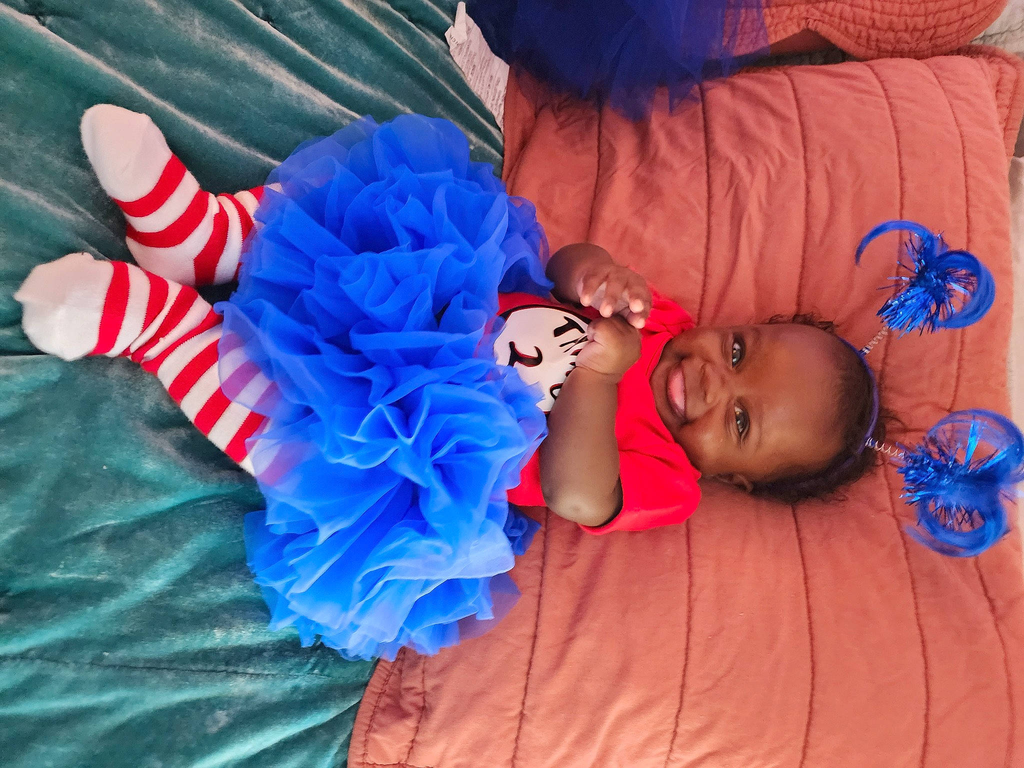 Devan is registered to the contest to win money with this photo: arm, azure, baby, baby_toddler_clothing, blue, comfort, electric_blue, finger, fun, hand, happy, headgear, human_body, joy, orange, person, pink, purple, red, textile