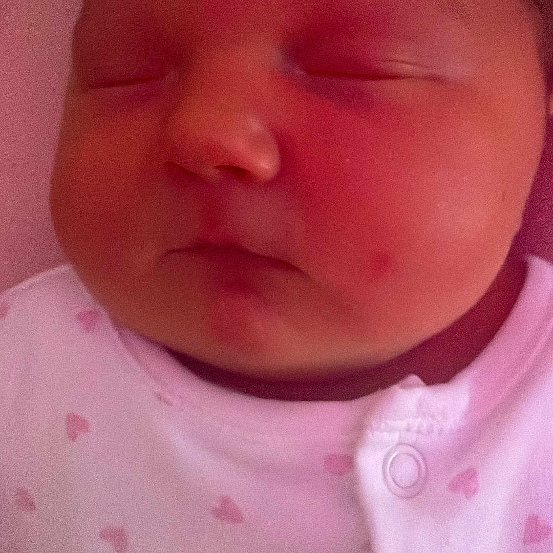 Lyla is registered to the contest to win money with this photo: baby, bonnet, clothing, cushion, face, frown, hat, head, homedecor, newborn, person, photography, portrait, sad, sleeping