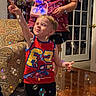 adult, boy, bubble_machine, bubbles, carpet, child, door, furniture, happy, indoor, living_room, patterned_sofa, person, playful, red_shirt, shorts, smiling, spiderman, toy, wood_floor