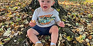 Kadence is registered to the contest to win money with this photo: autumn, baby, barn, child, clothing, daytime, grass, leaves, mickey_mouse, nature, outdoor, park, person, playground, roots, shoes, smiling, sunlight, toddler, tree