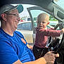 Kadence joined the competition — help win amazing prizes! man, child, toddler, car, steering_wheel, smile, cap, glasses, blue_shirt, window, door, sunlight, hand, vehicle, interior, seat, happy, person, casual_clothing, daytime
