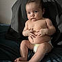 Anastasia is registered to the contest to win money with this photo: baby, infant, diaper, child, sitting, skin, hands, feet, serious_expression, indoors, fabric, dark_background, curious_eyes, plump, portrait, young_child, bare_chest, human, cute, soft_lighting