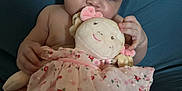 Anastasia joined the competition — help win amazing prizes! baby, child, plush_doll, soft_toy, pink_dress, floral_pattern, sitting, curious, indoor, cute, face, hands, legs, skin, head, expression, comfort, background, nurture, infant