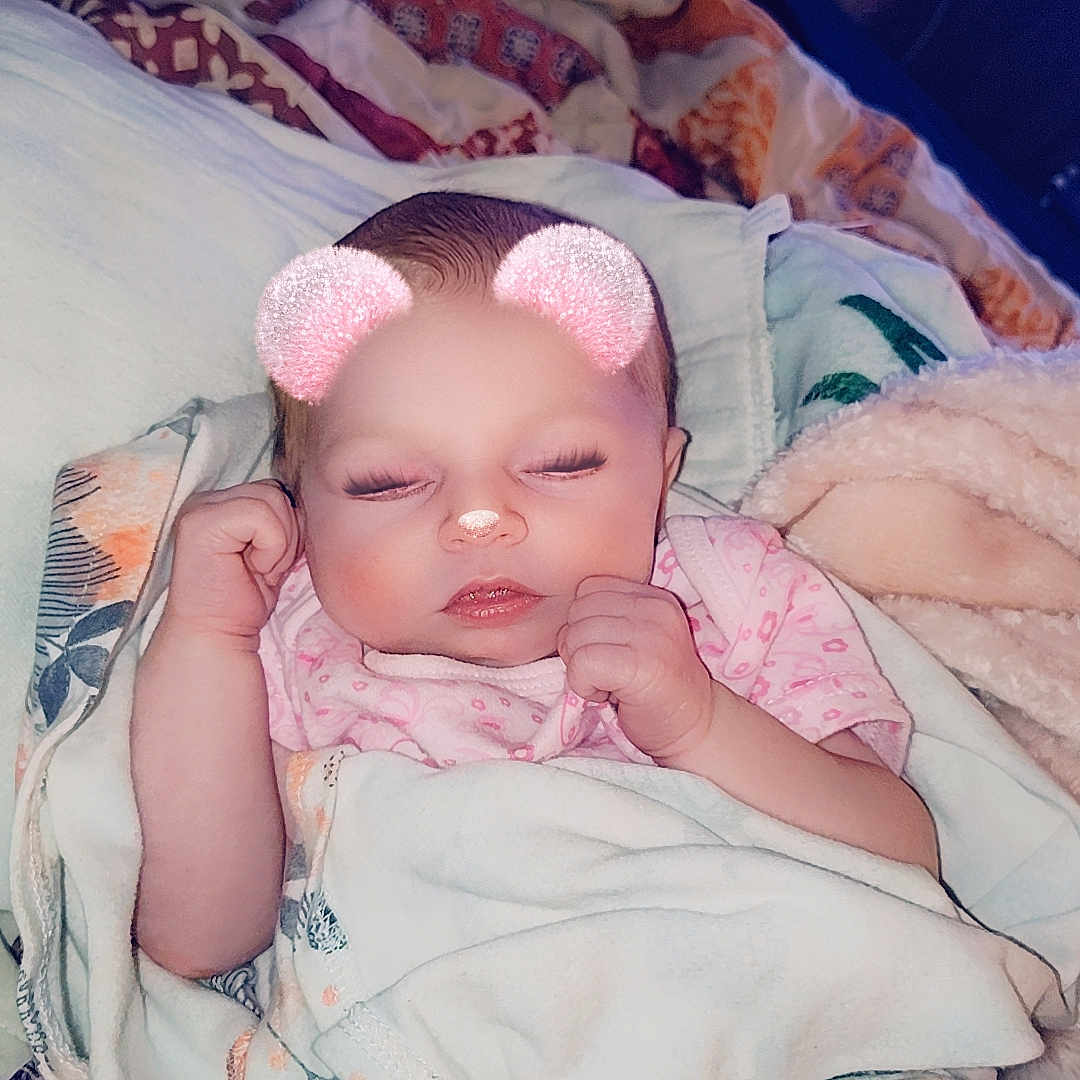 Emery is registered to the contest to win money with this photo: baby, bed, blanket, bodypart, bonnet, cap, clothing, couch, face, finger, furniture, hand, happy, hat, head, newborn, person, photography, portrait, smile