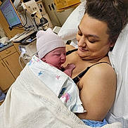 Braylynn is registered to the contest to win money with this photo: newborn, baby, mother, hospital, blanket, bed, medical_equipment, cap, woman, infant, love, care, gaze, indoor, healthcare, patient, tenderness, family, postpartum, portrait