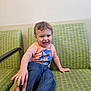 Braylynn joined the competition — help win amazing prizes! toddler, child, smiling, sitting, orange_shirt, blue_jeans, green_couch, indoor, hand, adult, furniture, happy, cute, person, portrait, casual, playful, young_child, home_interior, interaction