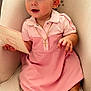 baby, child, pink_dress, chair, cushion, card, necklace, cross, earring, barefoot, indoor, carpet, cute, portrait, sitting, happy, person, infant, smile, curious