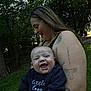 Alexander joined the competition — help win amazing prizes! baby, smiling, woman, tattoo, outdoor, park, grass, trees, person, happy, child, nature, casual_clothing, daylight, family, holding, joy, portrait, head, face