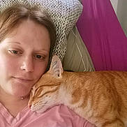 Pumpkin a rejoint le concours — aidez-le/la à gagner de superbes lots ! person, cat, ginger_cat, sleeping_cat, bed, pillow, pink_clothing, closeup, indoor, resting, cozy, snuggling, relaxation, pet, companion, portrait, human_face, animal, feline, comfort