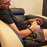 Stella a rejoint le concours — aidez-le/la à gagner de superbes lots ! man, glasses, cat, armchair, black_shirt, shorts, indoor, pet, relaxing, seated, furniture, home, comfort, light, beige, black, texture, hand, resting, casual