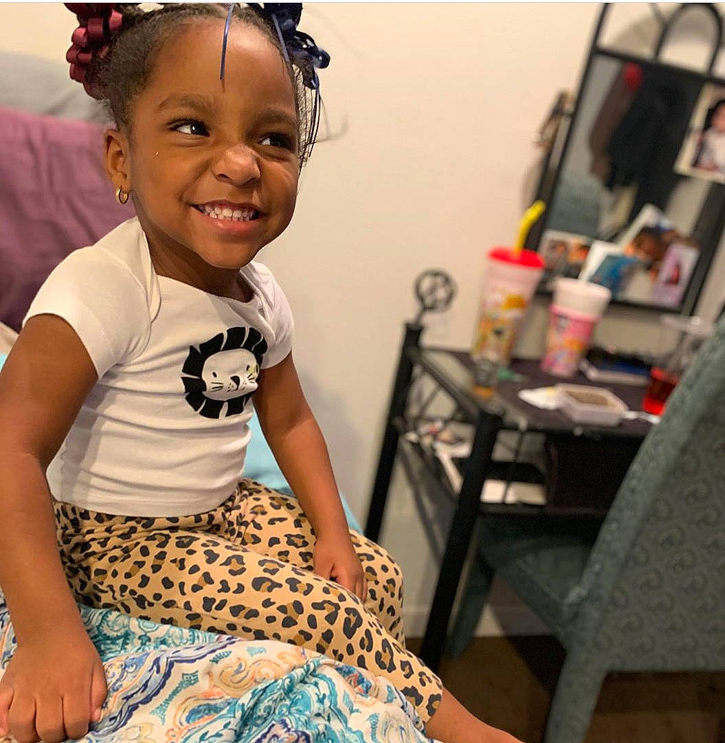 Ma'Laia is registered to the contest to win money with this photo: adaptation, black_hair, cheek, child, dress, ear, face, forehead, hair, hair_accessory, hairstyle, happy, head, joy, people, person, room, sitting, skin, smile