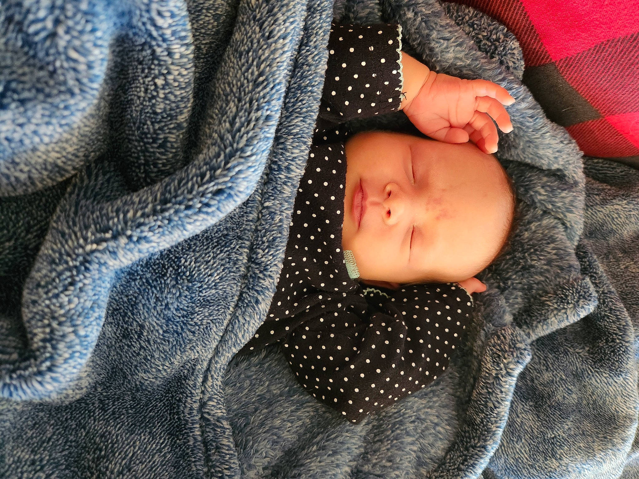 Isabelle is registered to the contest to win money with this photo: arm, baby, baby_toddler_clothing, comfort, denim, electric_blue, eye, face, grey, head, human_body, knit_cap, linens, pattern, person, sleeve, textile, toddler, wood, wool