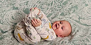 Dashiell joined the competition — help win amazing prizes! baby, infant, pajamas, blanket, pattern, smile, happy, child, cute, lying_down, hand, foot, face, head, skin, indoors, playful, cozy, comfort, expression