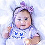 Manéa a rejoint le concours — aidez-le/la à gagner de superbes lots ! baby, blanket, bow, cheeks, child, cute, face, hand, headband, infant, lying_down, person, portrait, purple, shirt, skin, smile, soft_texture, sunny_day, text