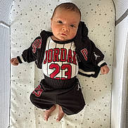 Elias joined the competition — help win amazing prizes! baby, infant, crib, baby_clothing, jordan, number_23, black_jacket, black_pants, star_pattern, baby_bedding, baby_face, newborn, cute, lying_down, indoor, soft_lighting, baby_gaze, baby_feet, baby_hands, child