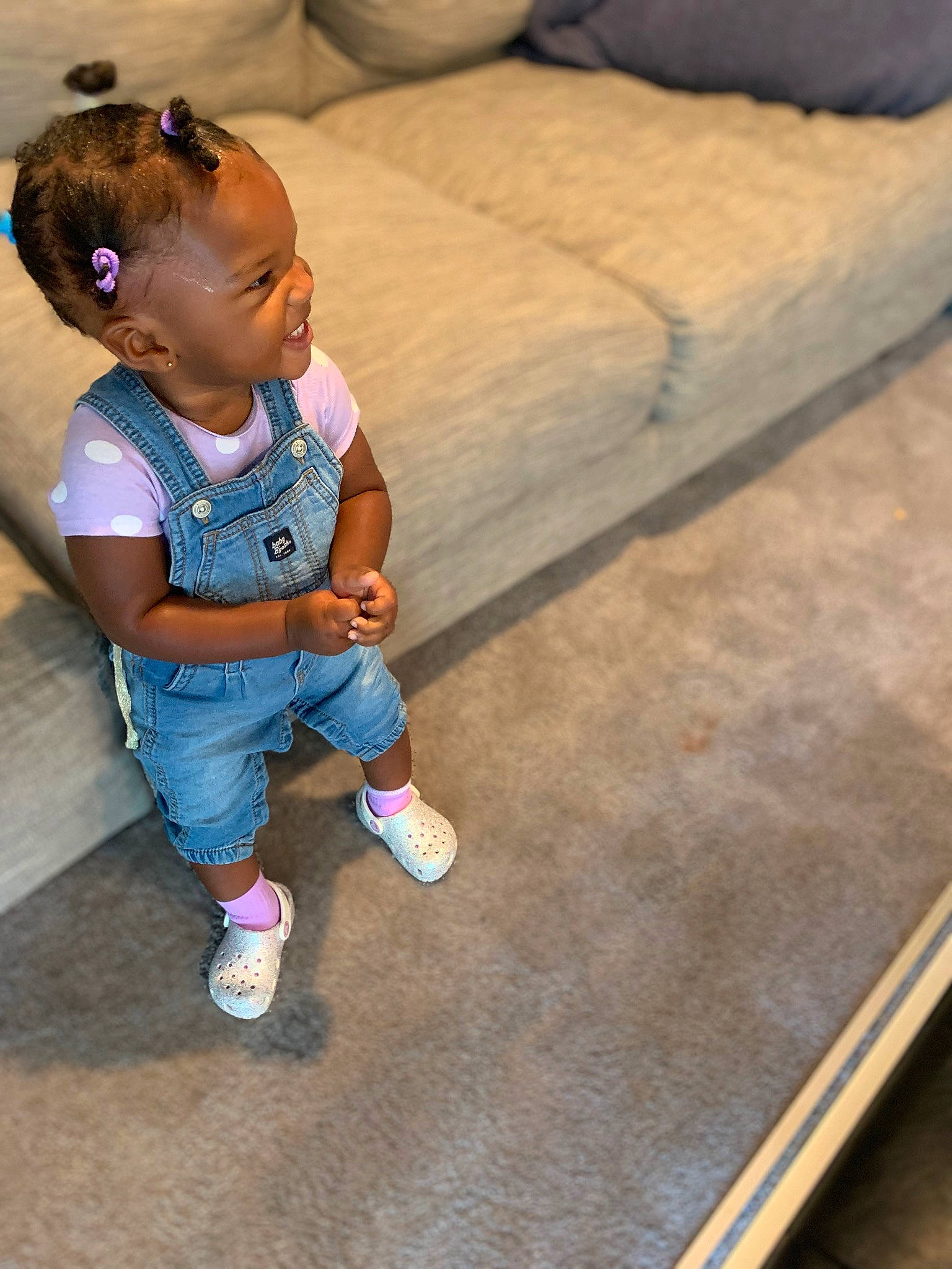 Janiyah joined the competition — help win amazing prizes! baby, baby_toddler_clothing, child, comfort, couch, electric_blue, floor, flooring, foot, fun, grass, happy, hardwood, human_leg, leisure, person, sitting, sock, toddler, wood