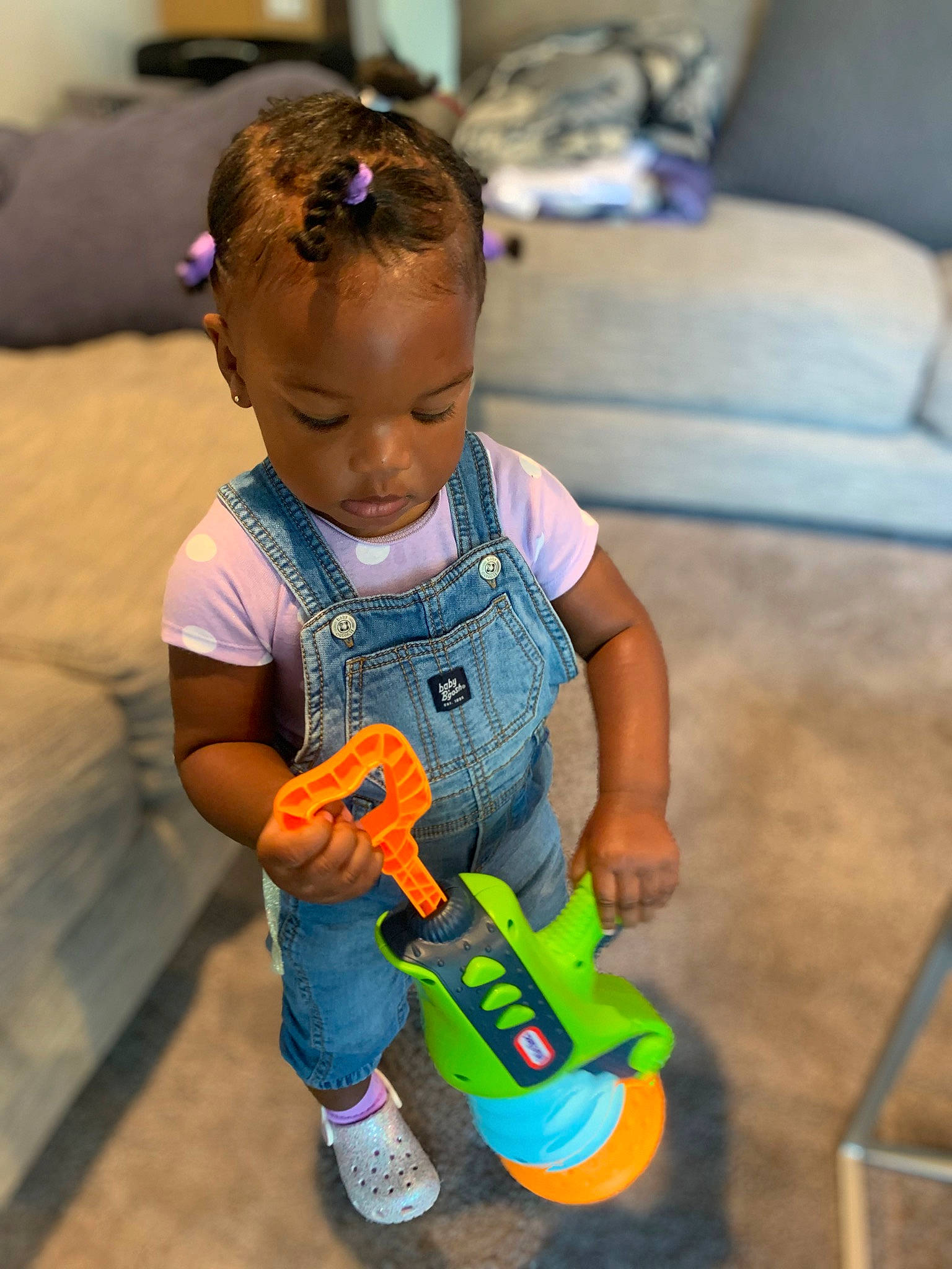 Janiyah is registered to the contest to win money with this photo: baby, baby_playing_with_toys, baby_toddler_clothing, child, comfort, couch, floor, flooring, fun, happy, person, play, room, sitting, skin, t_shirt, tire, toddler, toy, wheel