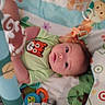 Shauann is registered to the contest to win money with this photo: baby, infant, child, playmat, toy, animal_print, tiger_face, green_shirt, soft_toy, colorful, curious, lying_down, wide_eyes, indoor, cute, young_child, baby_gym, pattern, playtime, infant_toys