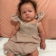 Nova joined the competition — help win amazing prizes! baby, bed, blanket, child, comfortable, cute, dress, expression, face, gingham, hair, indoors, infant, pattern, person, pillow, sitting, skin, socks, soft