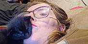 Luna joined the competition — help win amazing prizes! person, cat, kitten, black_cat, glasses, beard, couch, mattress, cushion, indoor, closeup, face, relaxing, pet, affection, home, casual, people, resting, comfort
