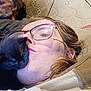 person, cat, kitten, black_cat, glasses, beard, couch, mattress, cushion, indoor, closeup, face, relaxing, pet, affection, home, casual, people, resting, comfort
