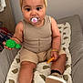Amaya participe au concours pour gagner de l'argent avec cette photo : baby, pacifier, headband, toy, beige_clothing, cushion, bear_pattern, sitting, child, indoor, footwear, bracelet, cute, infant, handheld_toy, smiling, plush, soft_toy, comfortable, young_child