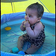 Amaya participe au concours pour gagner de l'argent avec cette photo : baby, infant, pool, water, toy, swimsuit, leopard_print, sitting, child, playtime, inflatable_pool, yellow_canopy, chewing, cute, summer, outdoor, floating_toys, chubby, water_play, heart_doodle