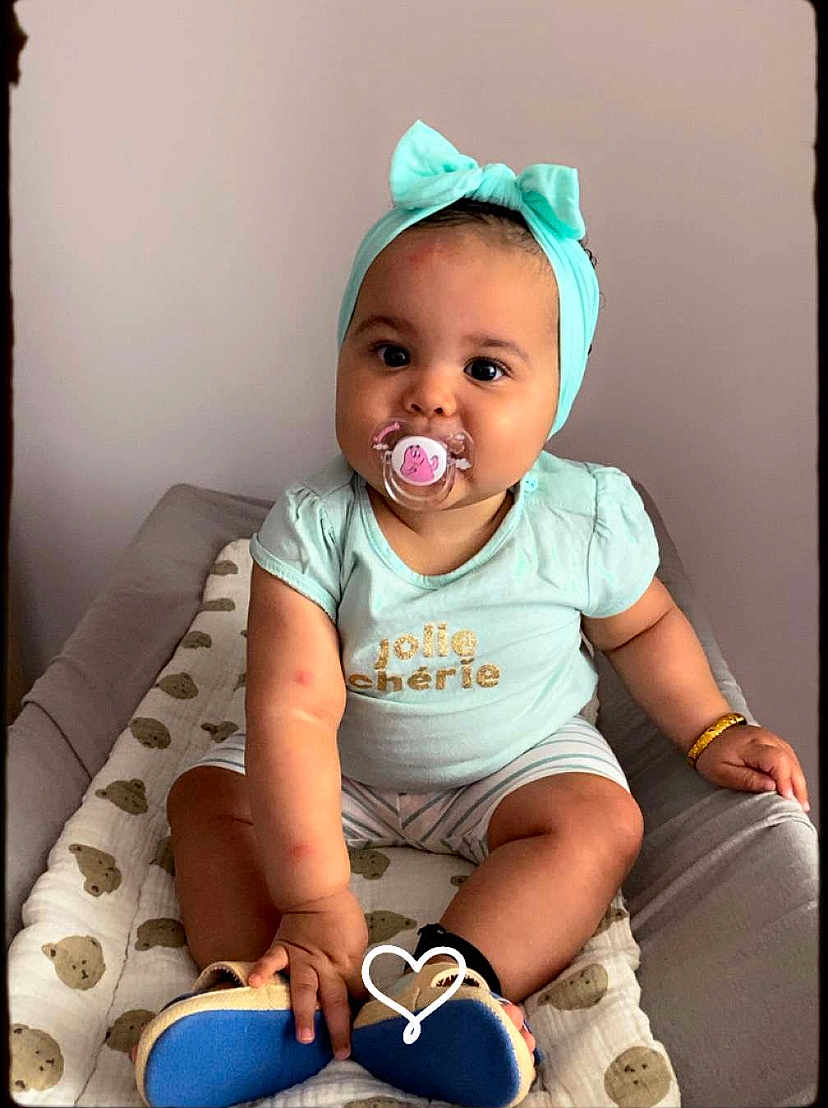 Amaya a rejoint le concours — aidez-le/la à gagner de superbes lots ! baby, pacifier, headband, mint_green, teddy_bear_pattern, blanket, cushion, sitting, cute, child, infant, clothing, bracelet, footwear, indoor, portrait, young_child, expression, looking, hand