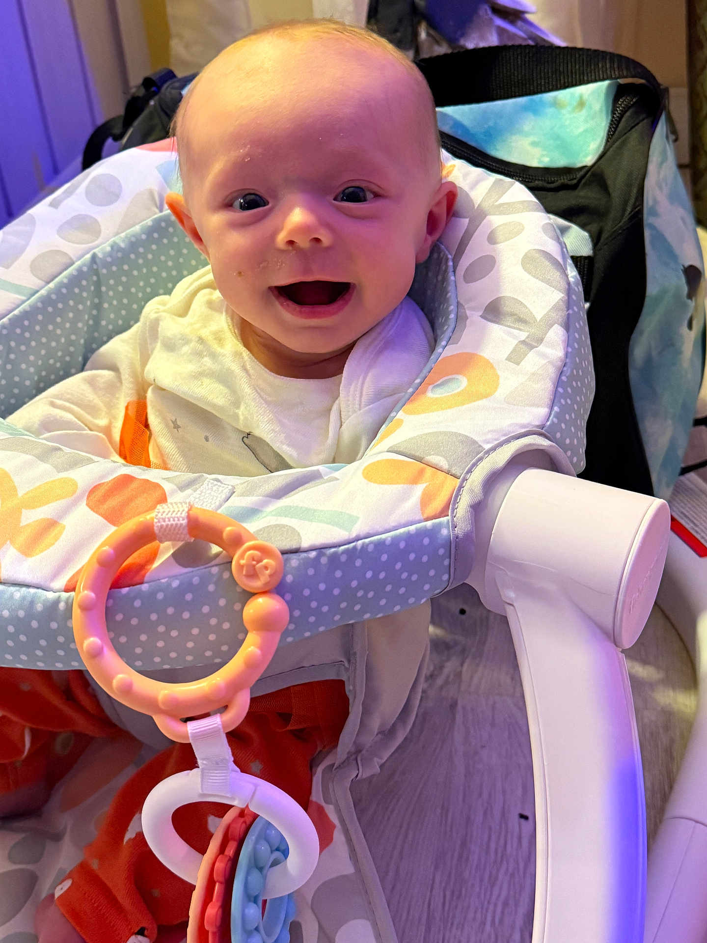 Aviya is registered to the contest to win money with this photo: accessory, baby, baby_seat, bright, child, clothing, colorful, comfort, cute, face, floor, happy, indoors, infant, joy, person, playtime, seat, smiling, toy_rings